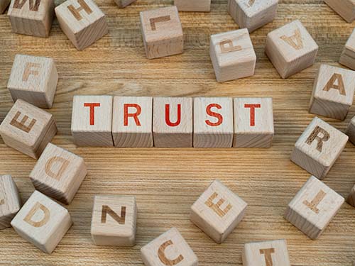 Wooden blocks with letters on them spelling 'trust'.